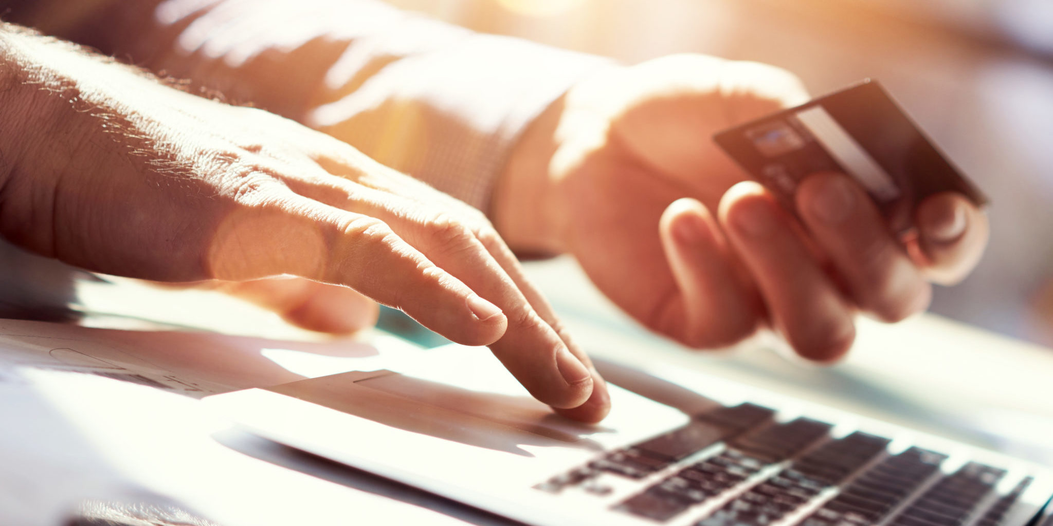 Closeup Man Holding Hand Credit Card.Businessman Use Laptop Online Payments Shopping.Guy Typing Keyboard Notebook Name Numbers Plastic Debit Kard Holder.Flares, Blurred Background